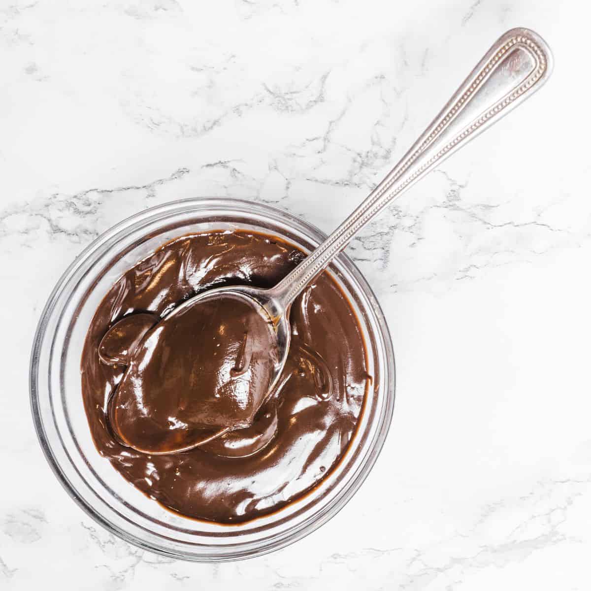 Healthy chocolate protein pudding in a cup with a spoon.