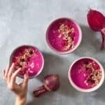 "Heart Beet Love" smoothie made with beets and strawberries in a bowl on a table decorated with beets.