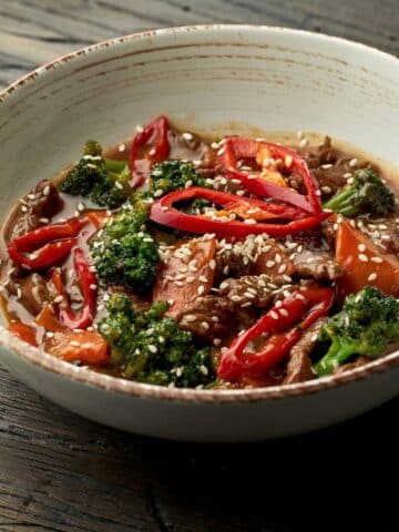 Sesame garlic beef with broccoli in a cermaic bowl.